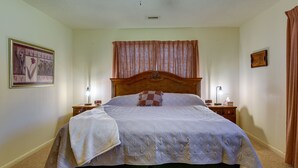 A neatly made bed with a quilt, a wooden headboard, and two bedside tables with lamps. - Vintage Chipley Getaway on Large Private Property (Chipley)