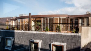 A modern building with a curved facade, large windows, and a balcony with plants. - ROOFTOP 3BR PH-INDOOR SAUNA IN DUBLIN (Dublin)
