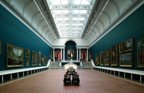 A grand hall with a high ceiling, a central staircase, and a row of framed artworks on the walls. - ROOFTOP 3BR PH-INDOOR SAUNA IN DUBLIN (Dublin)