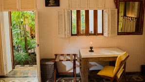 A room with a table, a chair, a candle, and a view of greenery outside. - Hotel CRC-8S Cerca al Mar con Desayuno  (Cartagena)