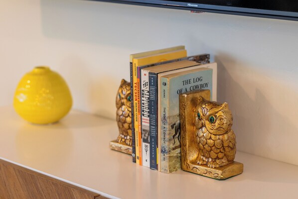 A bookshelf with books and decorative owl figures. - The Peaceful Valley-Views-Pool-Game Room-Comfy Beds-Waffles-Hiking@Saguaro West (Tucson)