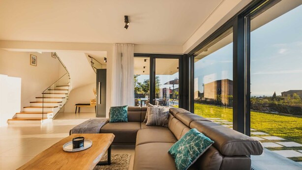 A modern living room with a leather sofa, wooden coffee table, and a staircase leading to an upper floor. - Villa Angelina - Idyllic 4 BD villa for 8 with pool close to Porec (Kaštelir)