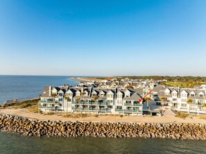 Un hôtel situé sur la côte, composé de bâtiments à plusieurs étages, avec un rivage rocheux et une vue sur la plage et l’océan.
