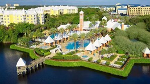 Et resort med en central pool, flere villaer og en dok, der strækker sig ud i vandet.