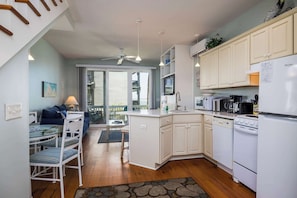 A kitchen with white cabinets, a microwave, a stove, and a refrigerator.