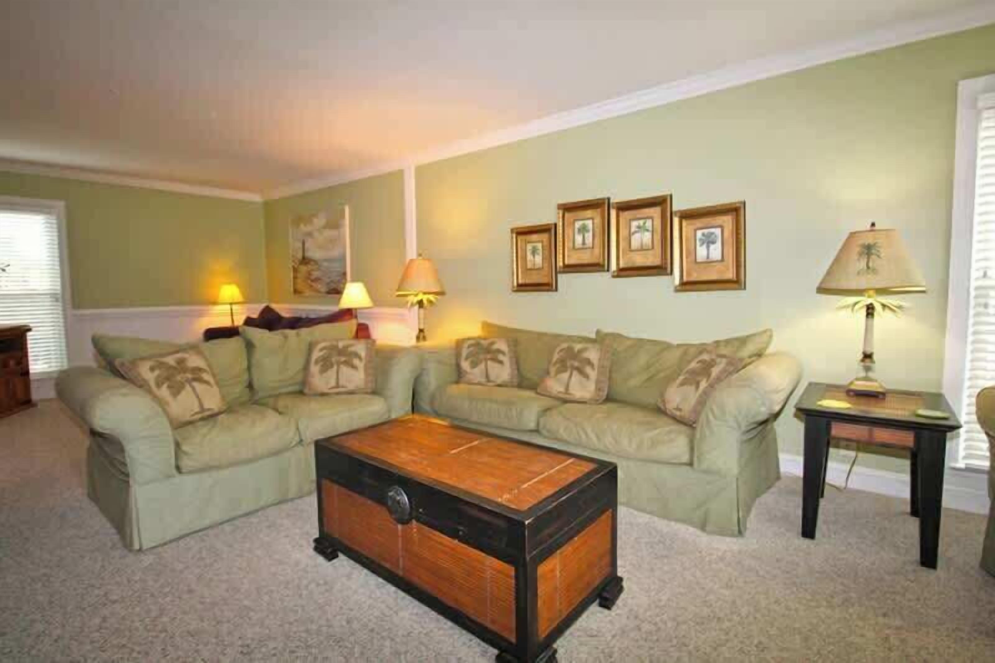 A living room with a sectional sofa, a wooden coffee table, and a small side table with a lamp.
