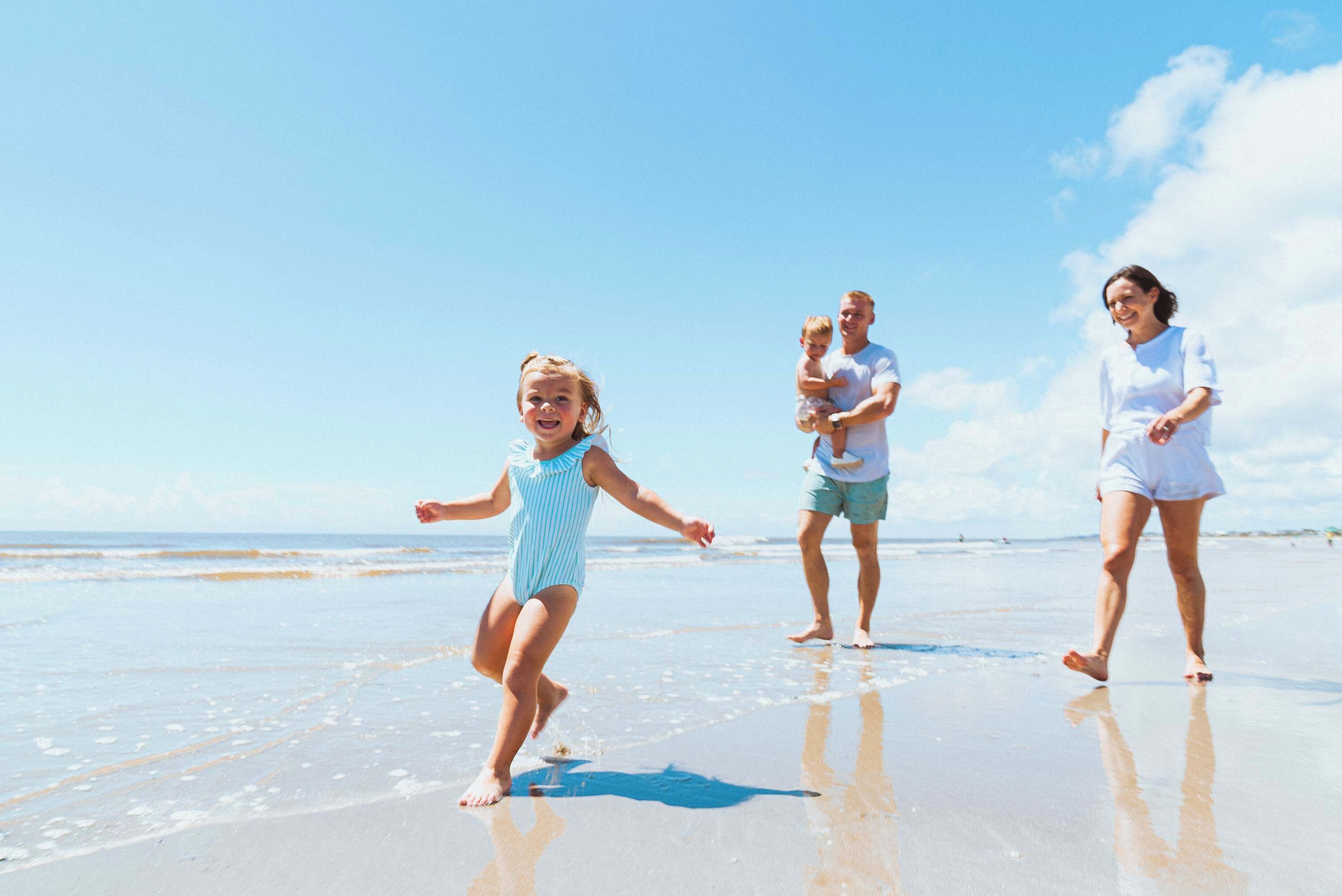 Eine Szene am Strand, eine Familie spaziert im Sand.