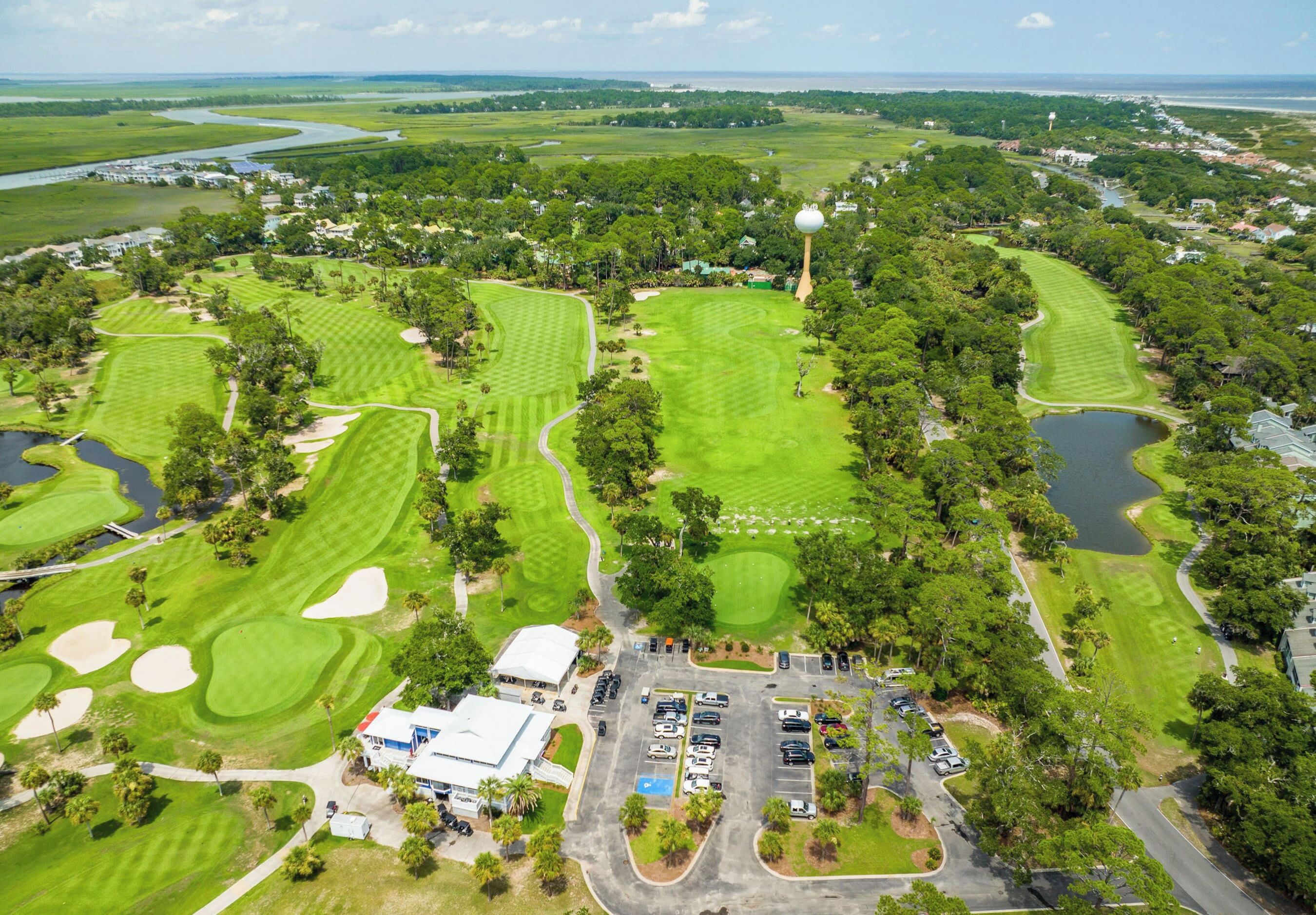 A golf course with multiple greens, sand bunkers, and a clubhouse.