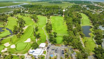 A golf course with multiple greens, sand bunkers, and a clubhouse.