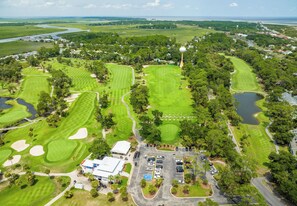 A golf course with multiple greens, sand bunkers, and a clubhouse.