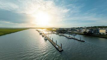 A riverfront marina with boats docked, a pier, and buildings along the riverbank.