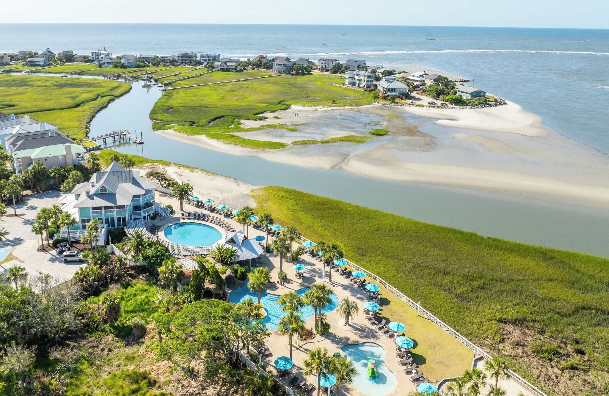 A coastal resort with multiple swimming pools, beachfront villas, and a marina.