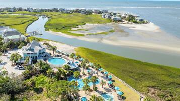 A coastal resort with multiple swimming pools, beachfront villas, and a marina.