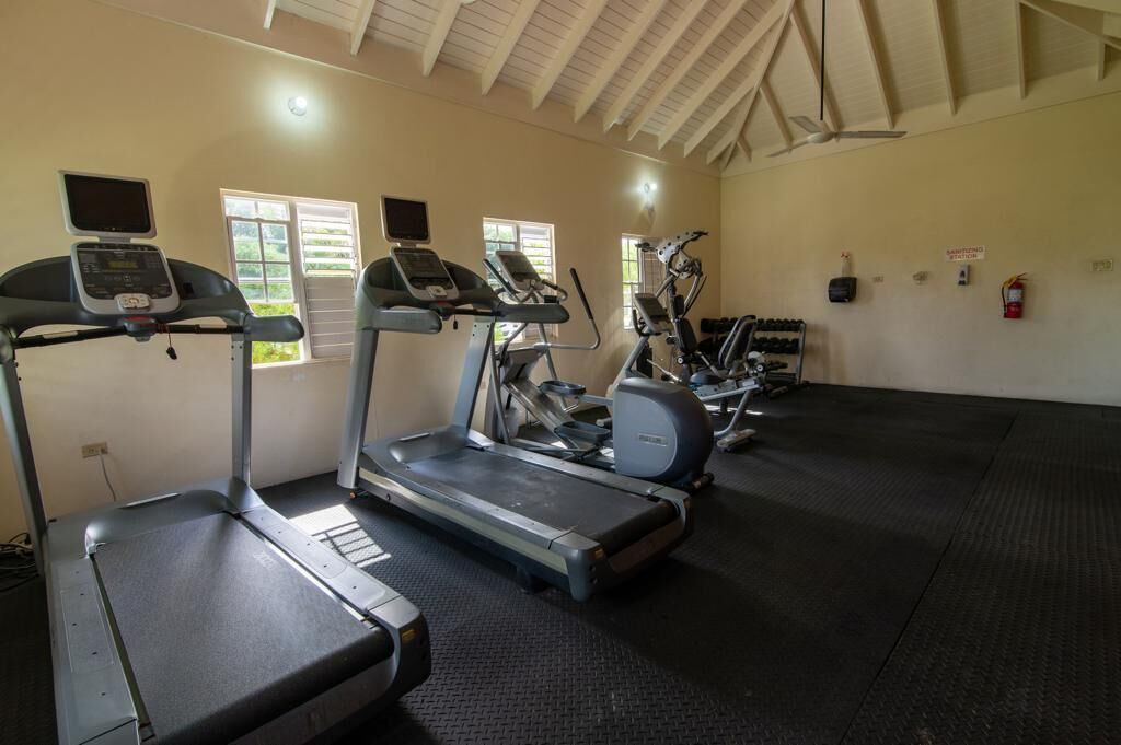 A gym with treadmills, elliptical machines, and stationary bikes.