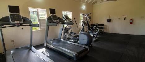 A gym with treadmills, elliptical machines, and stationary bikes.