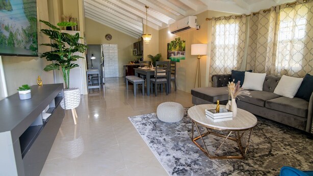 Una sala moderna con sofá, mesa de centro y comedor.