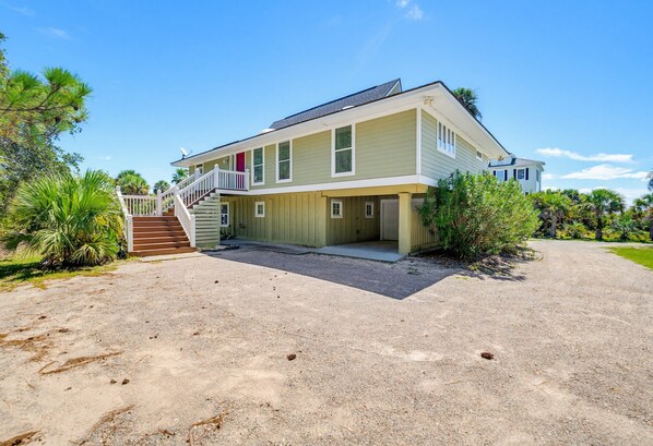 A two-story house with a front porch, a staircase, and a driveway.