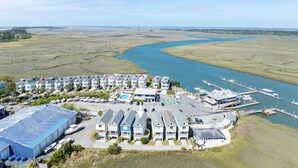 A coastal hotel with multiple-story buildings, a marina with boats, and a river in the background. - 867 Bonito Road (Fripp Island)