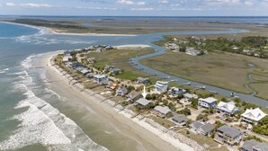 Vogelperspectief van een kustgebied met woningen, een strand en een rivier.