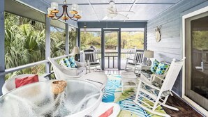 A covered porch with outdoor seating, a ceiling fan, and a view of the outdoors. - 395 Tarpon Blvd (Fripp Island)