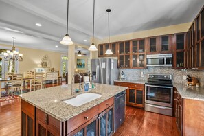A modern kitchen with granite countertops, stainless steel appliances, and wooden cabinetry.