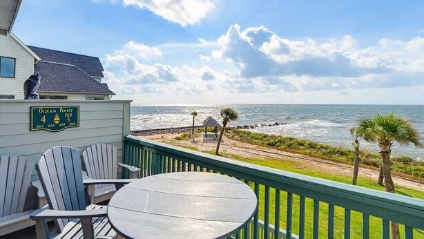 Un balcon avec vue sur l’océan, un panneau indiquant « Ocean Point, trou n° 4, par 4 », et un petit kiosque.