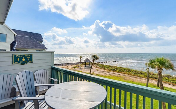Un balcon avec vue sur l’océan, un panneau indiquant « Ocean Point, trou n° 4, par 4 », et un petit kiosque.