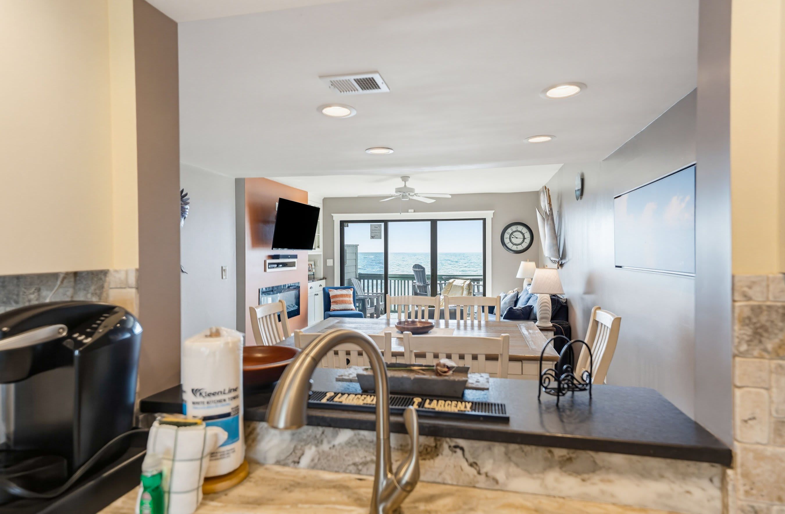 A kitchen with a marble countertop, a built-in range hood, and a view to the outside.