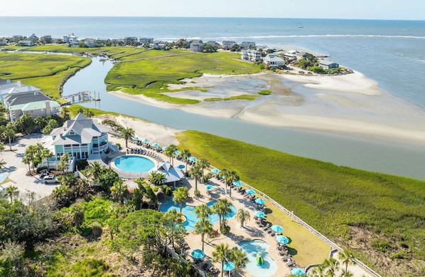A coastal resort with multiple swimming pools, beachfront villas, and a marina.