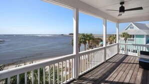 A covered porch with a view of the ocean, white railings, and a ceiling fan. - 12 Sea Mist Road (Fripp Island)