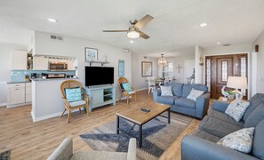 A spacious living room with a sofa, a coffee table, and a television. - 143 Captain John Fripp Villa - The Lone Palm (Fripp Island)