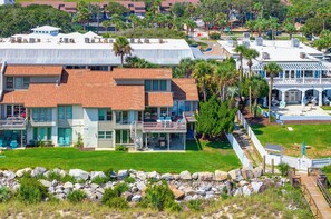 A coastal property with a large house featuring a balcony, a pool, and a view of the ocean. - 143 Captain John Fripp Villa - The Lone Palm (Fripp Island)