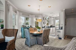 A dining area with a round table, chairs, and a hanging light fixture. - 302 Ocean Point Drive (Fripp Island)