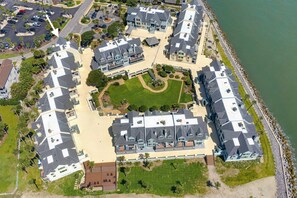 Un quartier résidentiel situé sur la côte, composé de plusieurs maisons à deux étages, d’une cour centrale et d’un accès à la plage.
