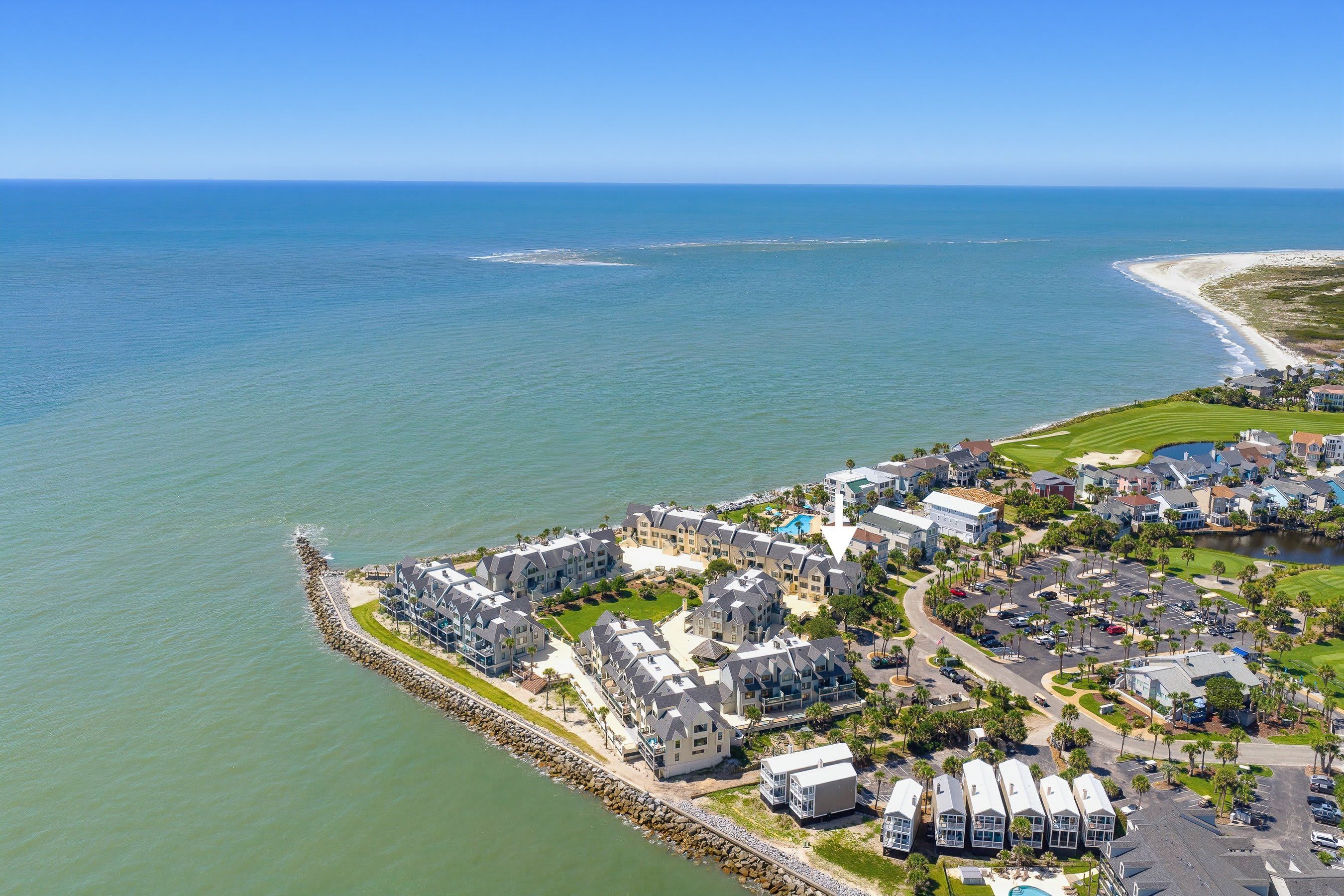 Un quartier résidentiel situé sur la côte, avec des propriétés donnant sur la plage, un terrain de golf et une marina.