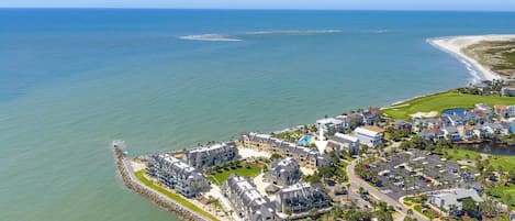 Una zona residencial costera con propiedades frente al mar, un campo de golf y un puerto deportivo.
