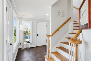 Un escalier avec des marches en bois et des rampes blanches menant à un palier.