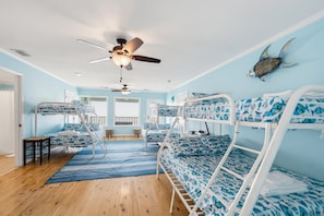 A room with bunk beds, a ceiling fan, and a fish decoration on the wall. - 407 Ocean Point Lane (Fripp Island)