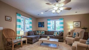 A living room with a ceiling fan, two sofas, a coffee table, and a chair. - 844 Marsh Dunes Road (Fripp Island)
