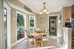 Enjoy meals at the glass-top table surrounded by comfortable chairs in this open-plan living space with a kitchen and washing machine.