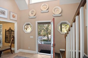 Staircase leads to a cozy upper level with decorative plates and artwork, including a seahorse and a shell, in a comfortable, inviting space.
