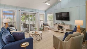 A living room with a sofa, armchairs, a coffee table, a TV, and a fireplace. - 721 Sea Dragon Lane (Fripp Island)