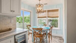 A kitchen with a dining table, chairs, and a hanging light fixture. - 721 Sea Dragon Lane (Fripp Island)