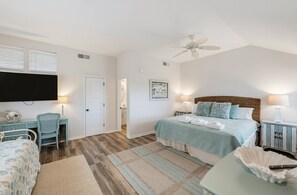 A bedroom with a bed, a desk, a chair, a television, and a ceiling fan. - 1 Periwinkle Ct (Fripp Island)