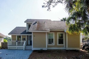 A two-story house with a front porch, a garage, and a small driveway.