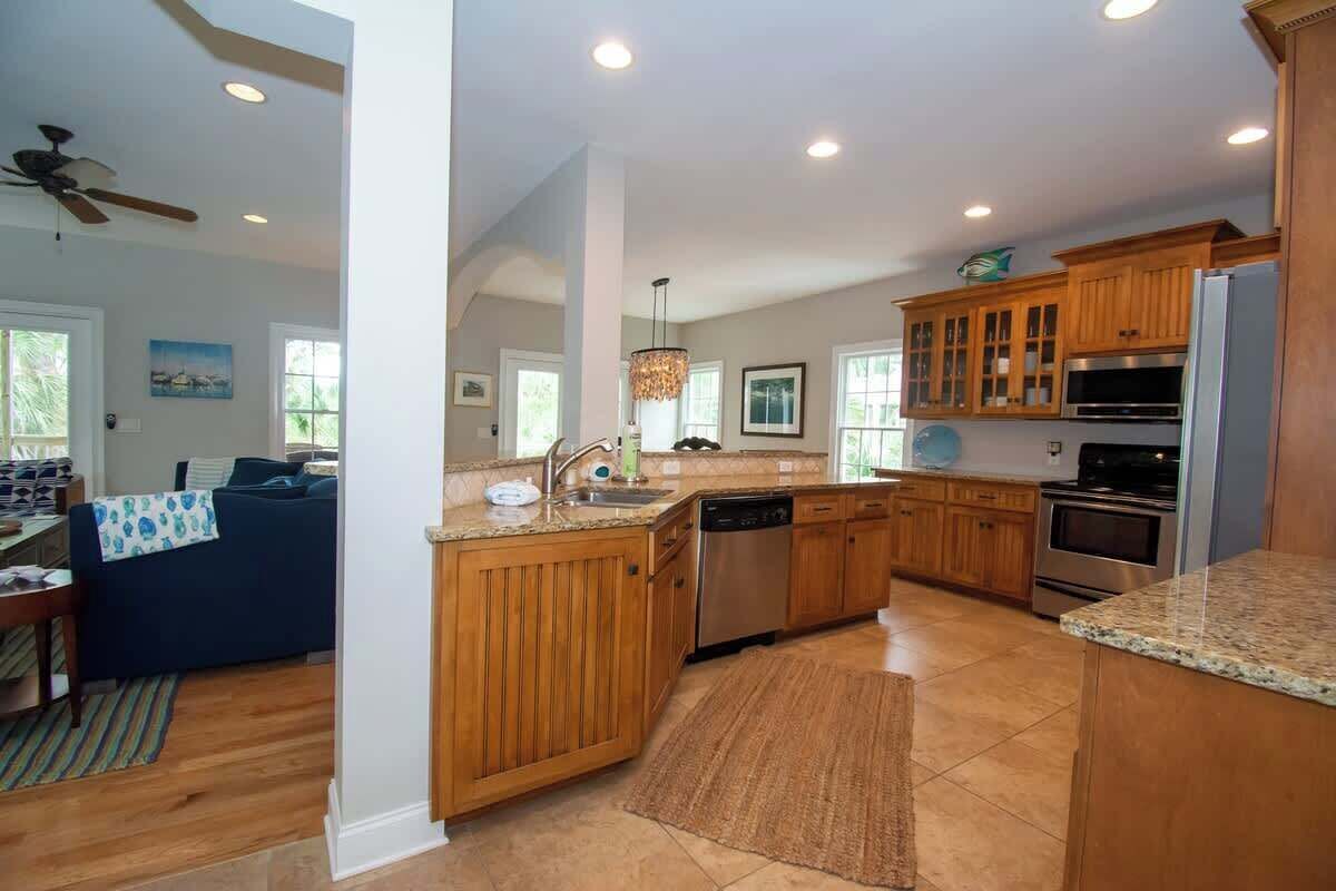 A modern kitchen with wooden cabinets, stainless steel appliances, and a granite countertop.