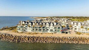A coastal hotel with multiple-story buildings, a rocky shoreline, and a view of the sea. - 625 Newhaven (Fripp Island)