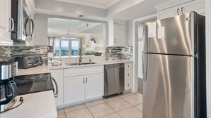 A modern kitchen with stainless steel appliances, white cabinetry, and a large island. - 625 Newhaven (Fripp Island)