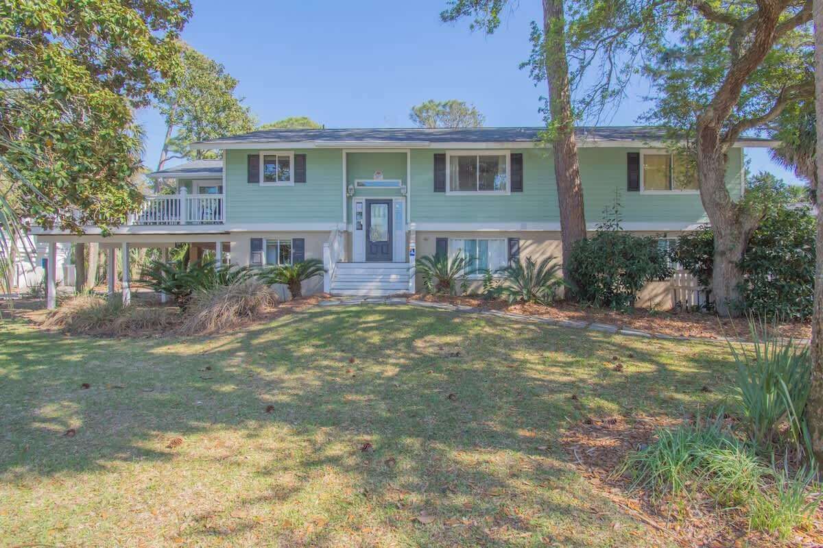 A two-story house with a front porch, a small front yard, and a driveway.