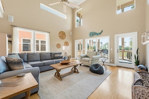 A spacious living room with a grey sofa, a wooden coffee table, and a patterned rug. - 125 Ocean Creek Blvd (Fripp Island)
